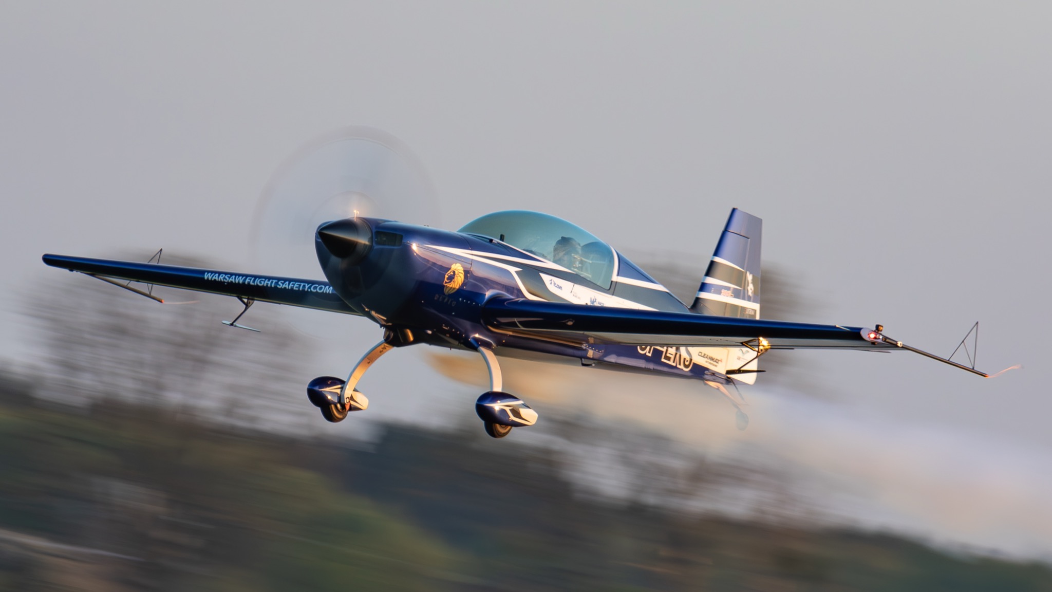 Extra 300L flying just above the ground at golden hour