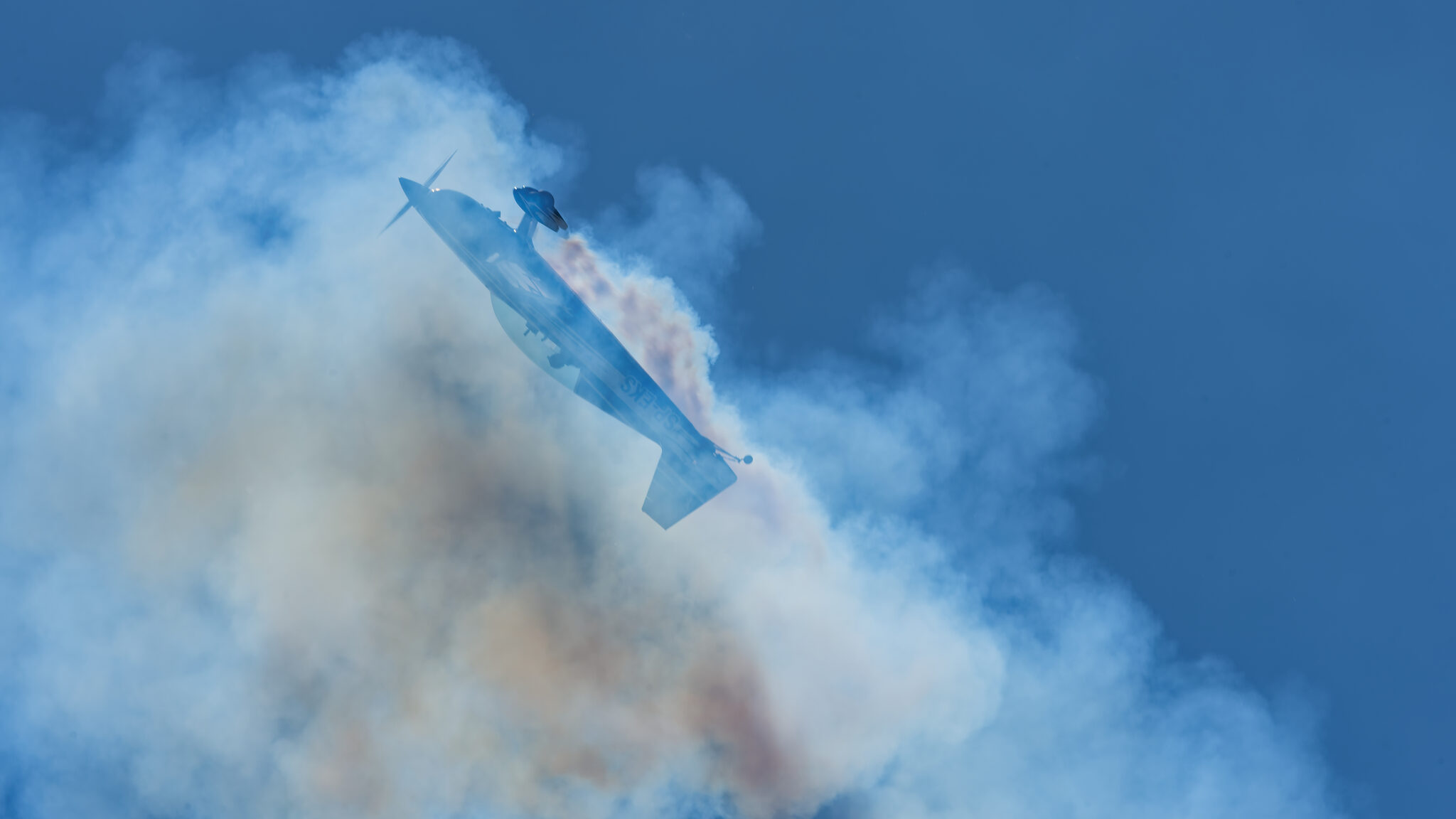 Extra 300L cutting through its own smoke trail
