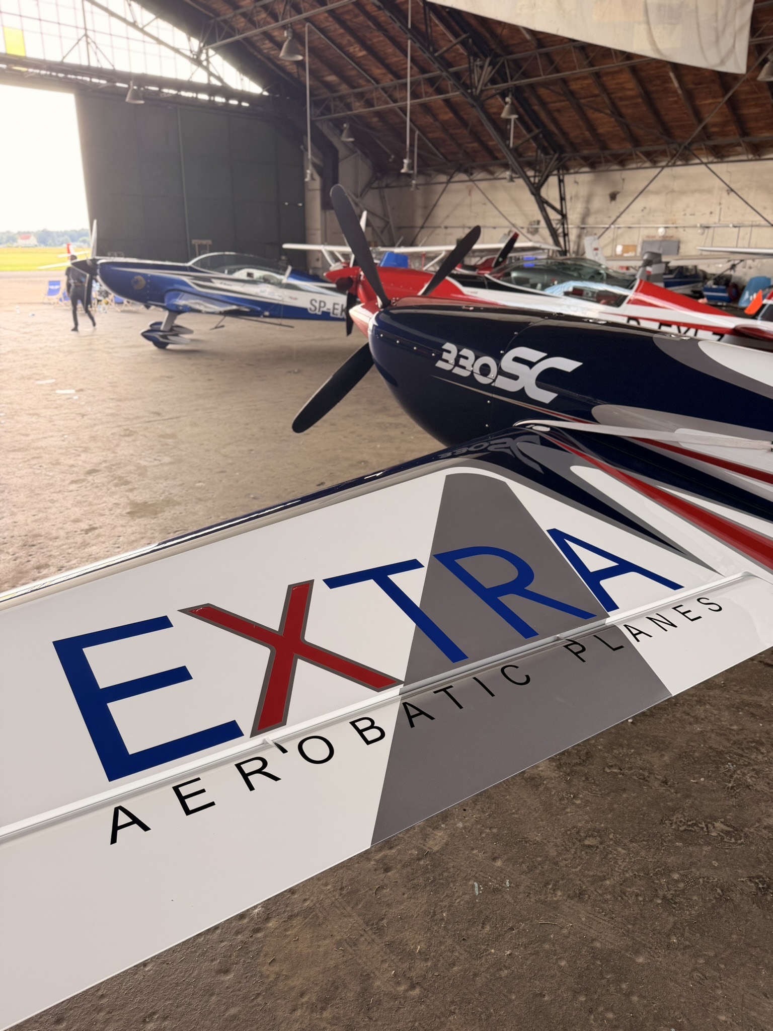Extra 300L SP-EKS i inne samoloty akrobacyjne Extra w hangarze Aeroklubu Gdańskiego podczas 60. Mistrzostw Polski